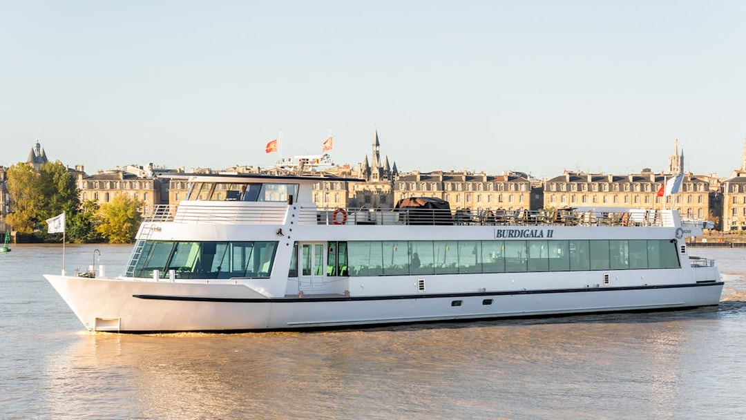 Bordeaux river cruise boat on the Garonne with cityscape in the background.
