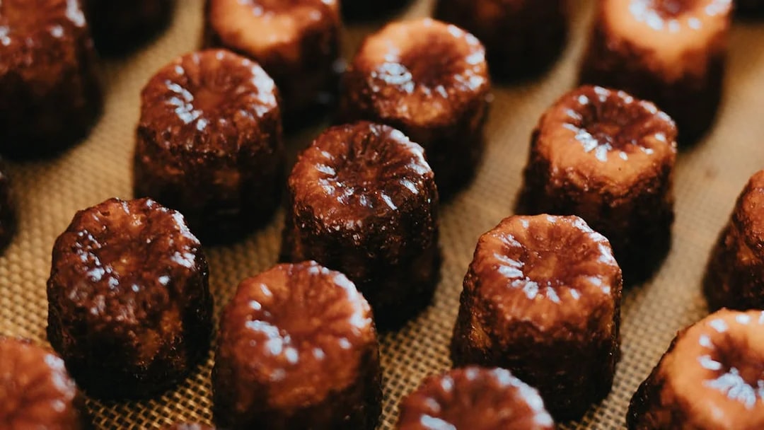 Canelés arranged on a tray for tasting on Bordeaux River Cruise.