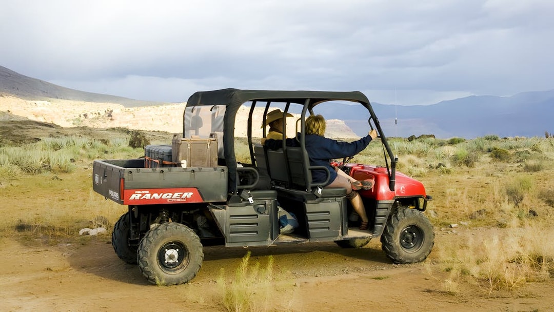 Guests riding a Polaris Ranger through a desert landscape.
