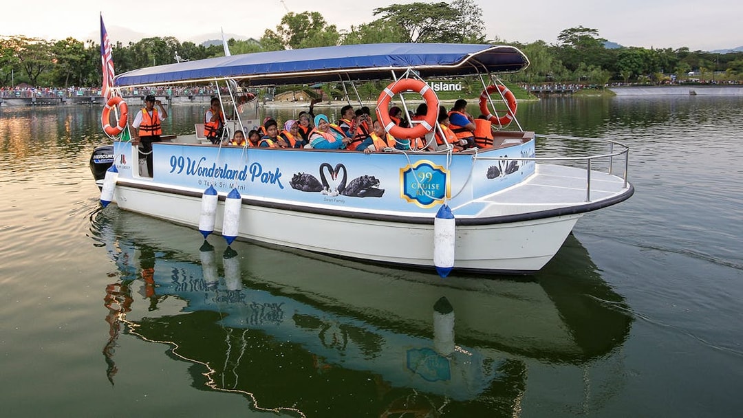 Boat tour at 99 Wonderland Park with passengers wearing life jackets.