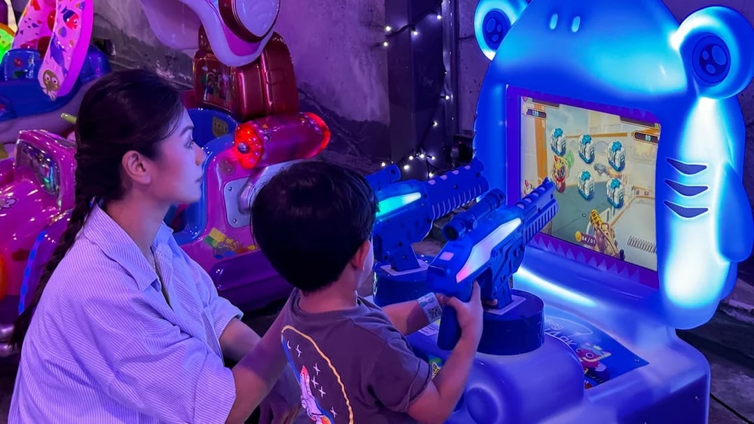 Child playing arcade shooting game at 99 Wonderland Park.