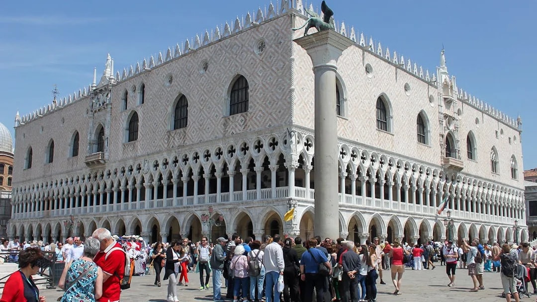 Tourists gather outside Doge's Palace in Venice during a walking tour.
