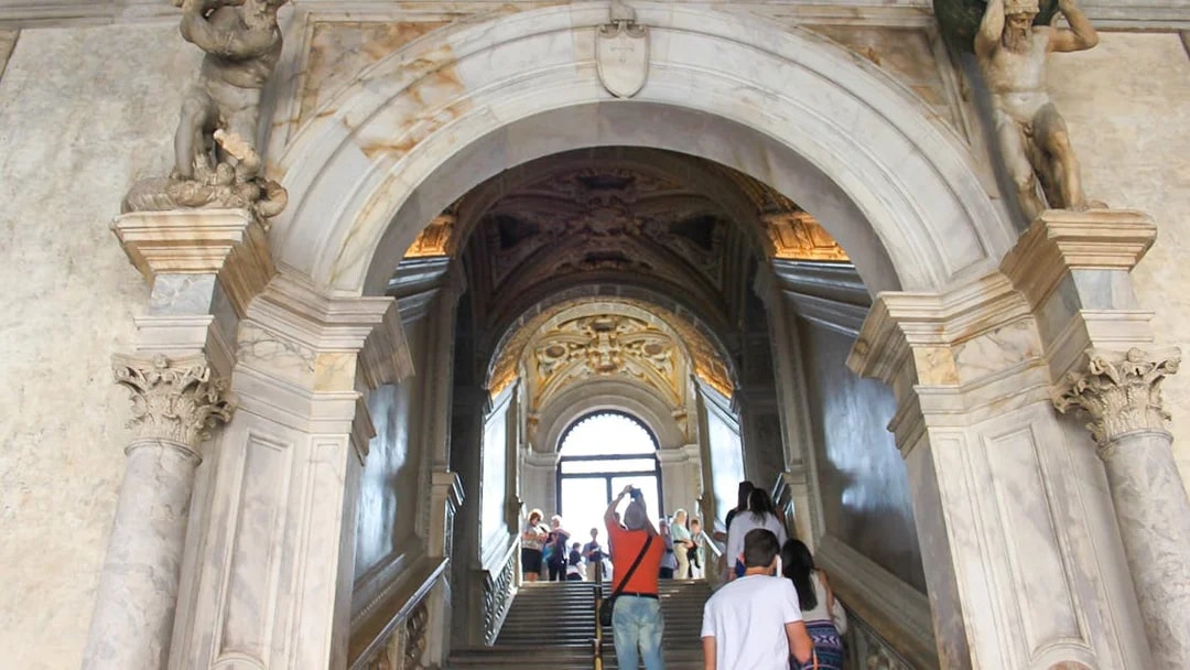 Visitors ascending staircase inside Doge's Palace, Venice.