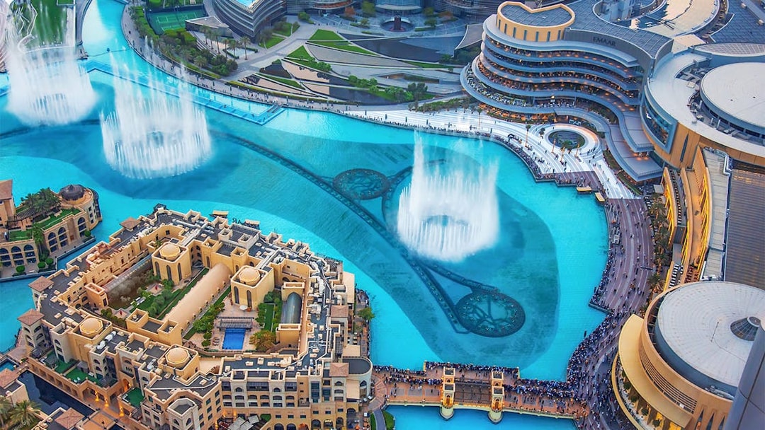 Dubai Mall fountain show with surrounding architecture and crowds.