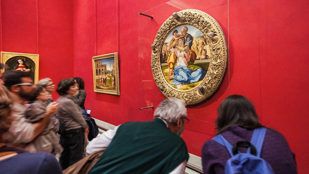 Tourists viewing Renaissance paintings at the Uffizi Gallery, Florence, Italy.