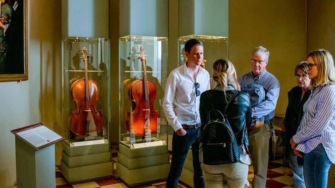 Tourists viewing cellos in Gallerie dell'Accademia, Venice.