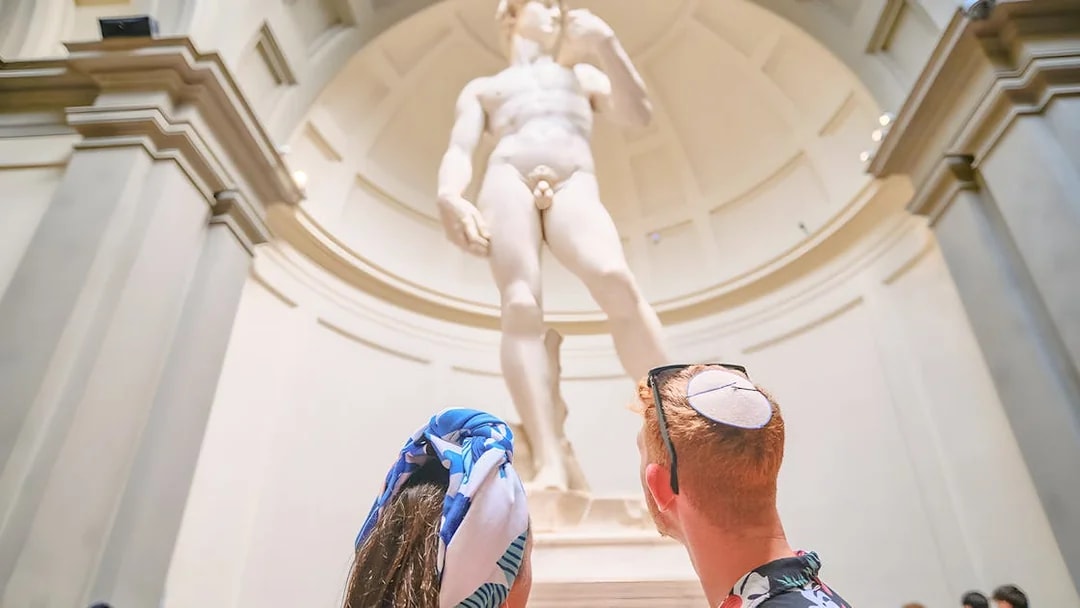 Couple admiring Michelangelo's David at Accademia Gallery, Florence.