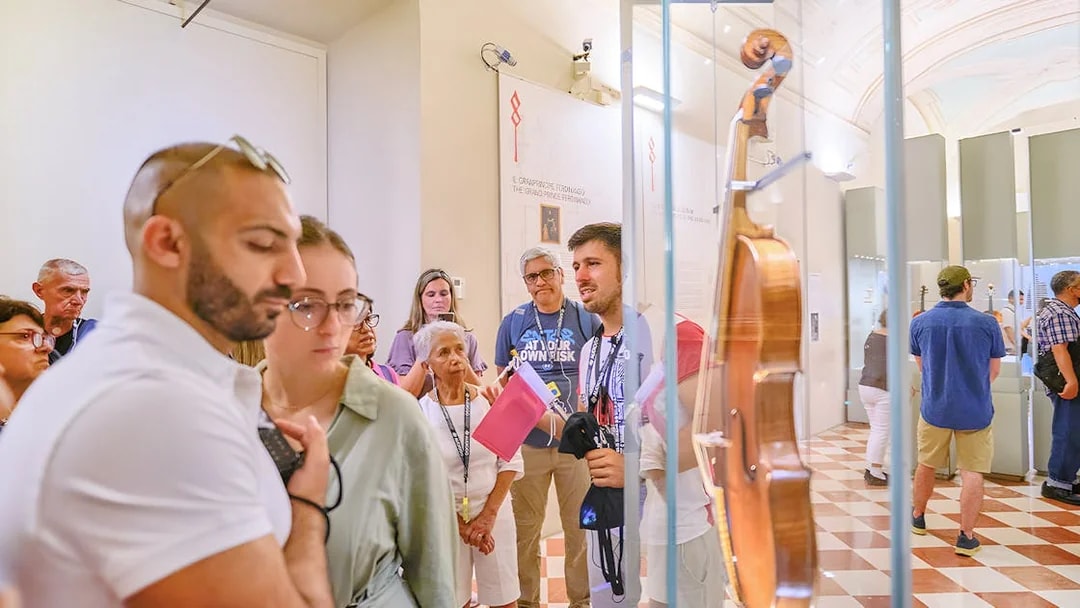 Tour group with guide viewing musical instruments at Accademia Gallery.