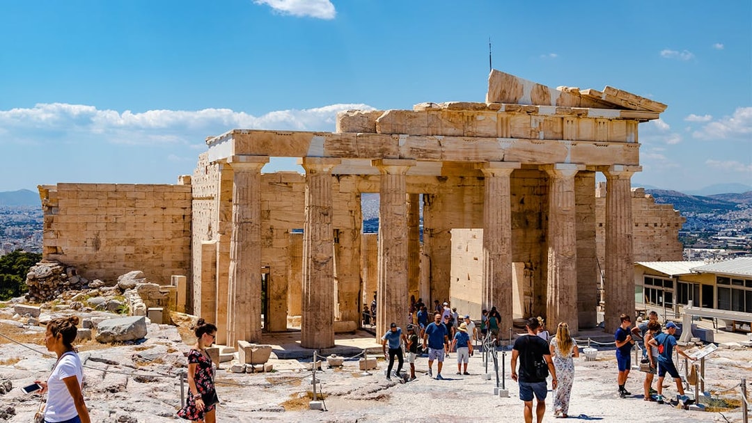 Visitors exploring the Propylaea at the Acropolis in Athens, Greece.