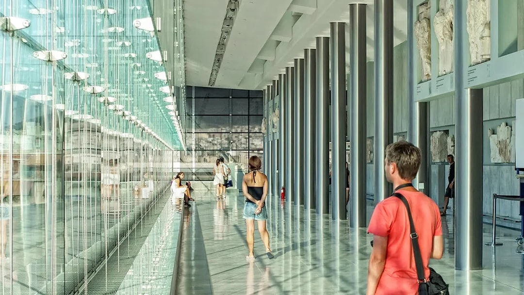 Visitors exploring the modern interior of the Athens Acropolis Museum.