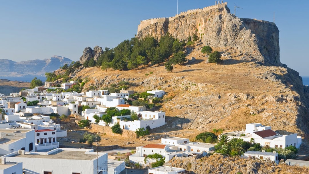 Acropolis of Lindos on a hilltop with white houses below, Rhodes, Greece.