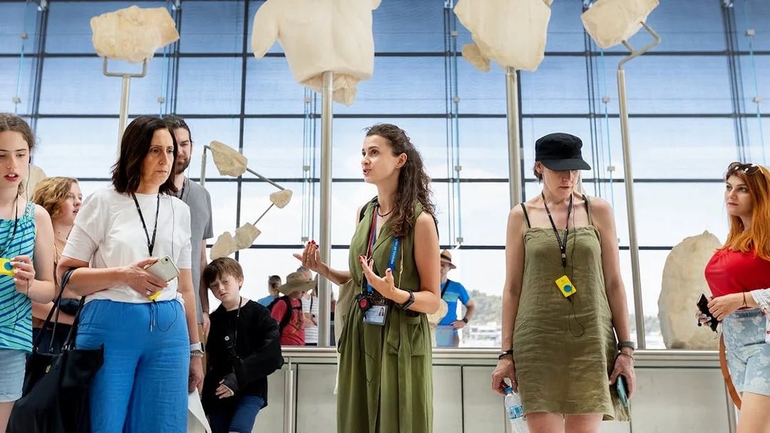 Tour group listening to a guide at the Acropolis Museum in Athens.
