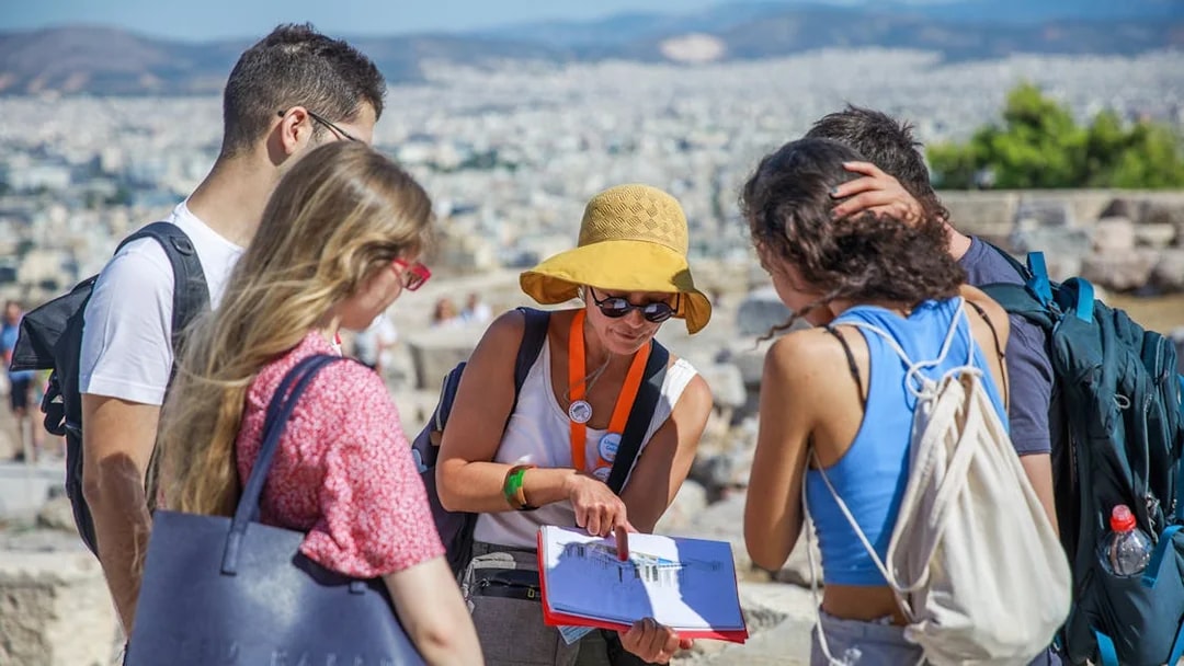Tour guide explaining Acropolis history to visitors in Athens.