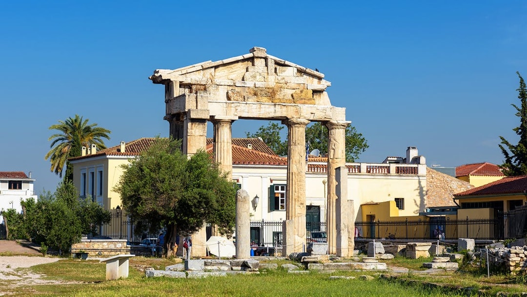 Ancient Greek columns at Roman Agora, Athens with surrounding buildings.