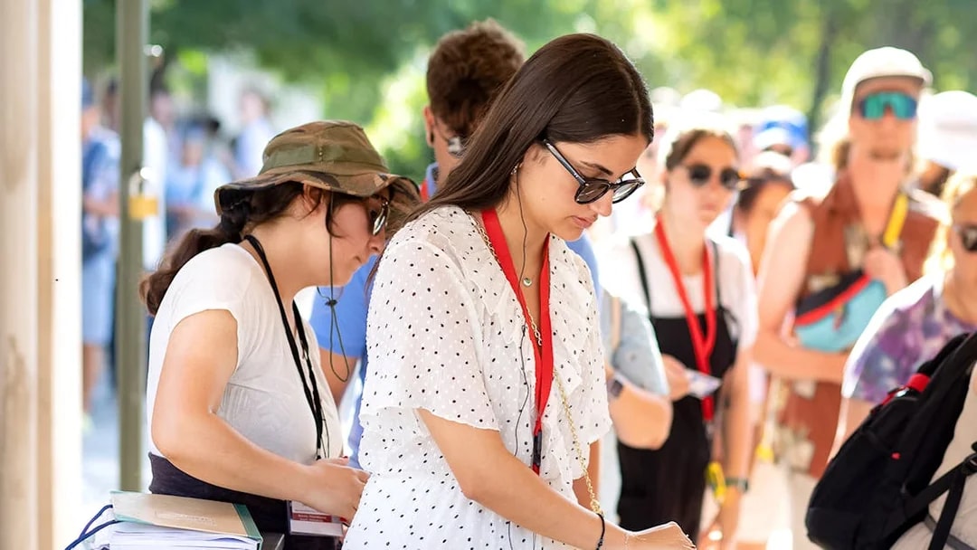 Visitors using audio guides at Acropolis Parthenon entrance.