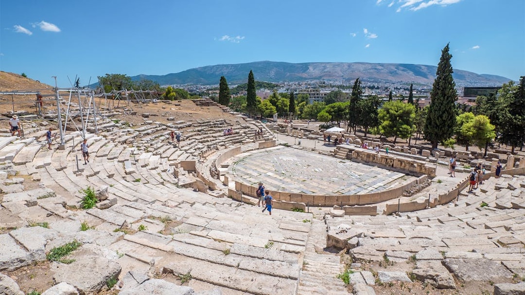Theatre of Dionysus ruins with visitors, Acropolis, Athens, Greece.