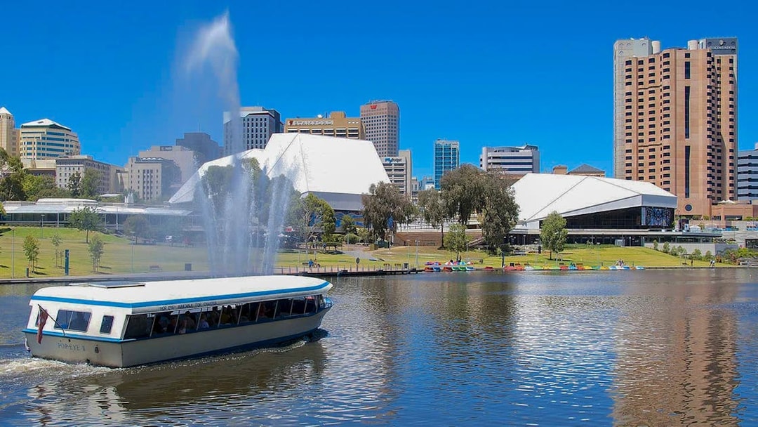 River cruise boat on Torrens River with Adelaide skyline in the background.