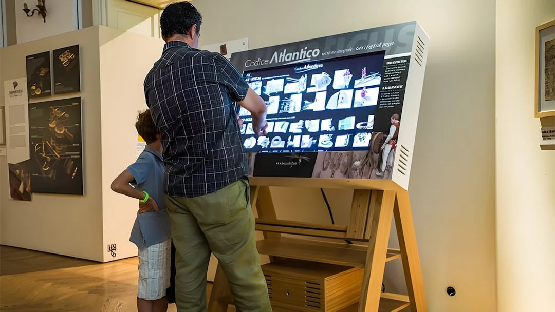 Visitors interacting with a digital display at Leonardo3 Museum, Milan.
