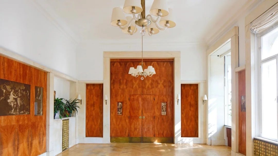 Adolf Loos-designed interior with wood paneling and chandelier in Wohnung Löwenbach.