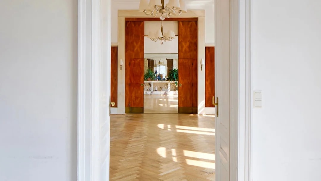 Interior view of Adolf Loos-designed Löwenbach apartment with wooden doors and parquet flooring.