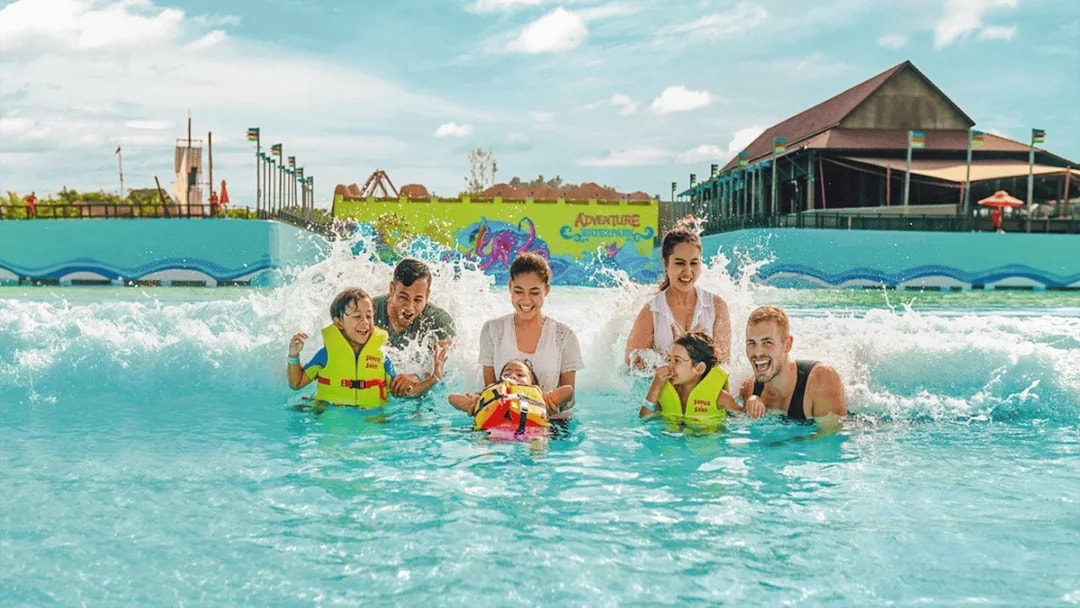 Family enjoying wave pool at Adventure Waterpark Desaru Coast.