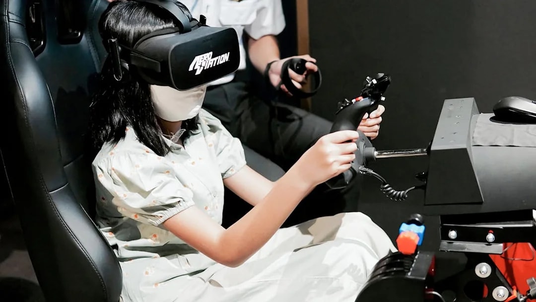 Person using a flight simulator with VR headset at Aeroviation Full Flight Experience.