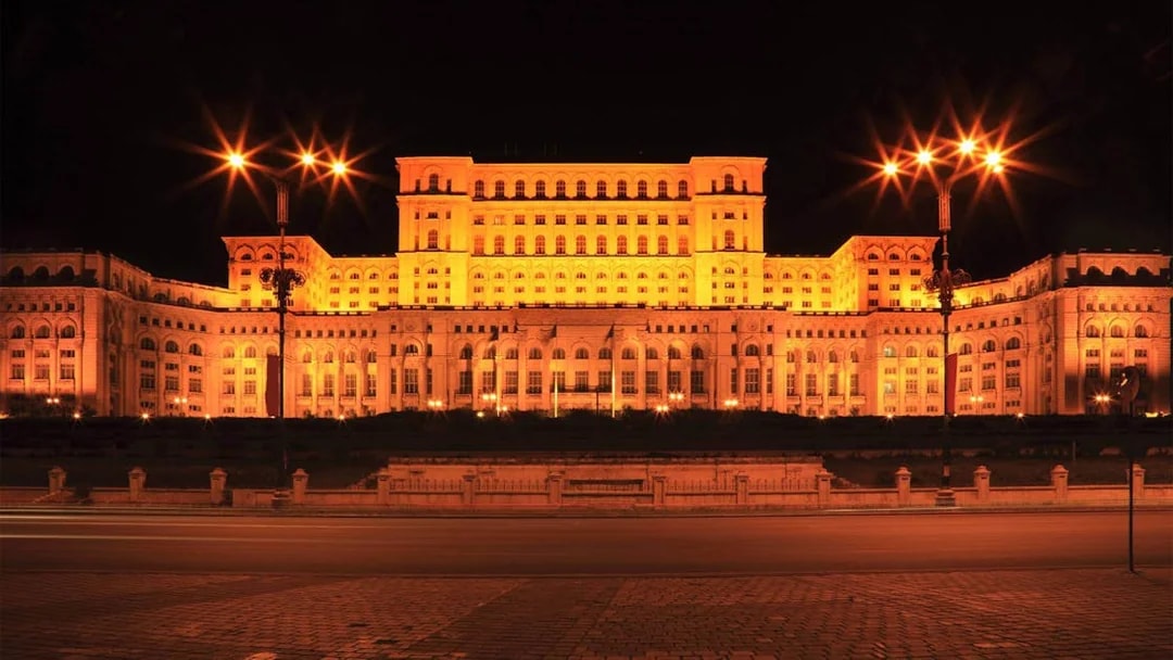 Palace of the Parliament illuminated at night during After Dark City Tour in Bucharest.