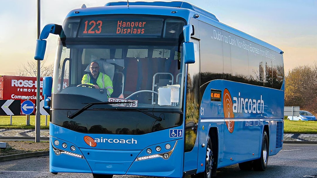 Dublin Aircoach bus for airport transfers on a city road.