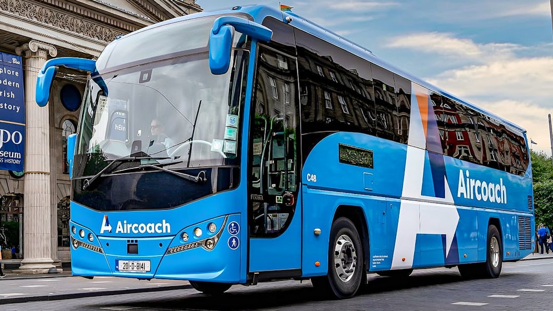 Dublin Aircoach bus for airport transfers in front of a historic building.