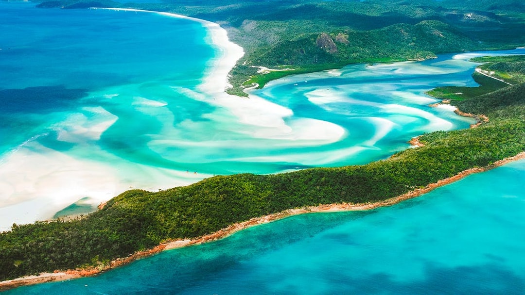 Aerial view of Whitsundays' turquoise waters and white sandy beaches.