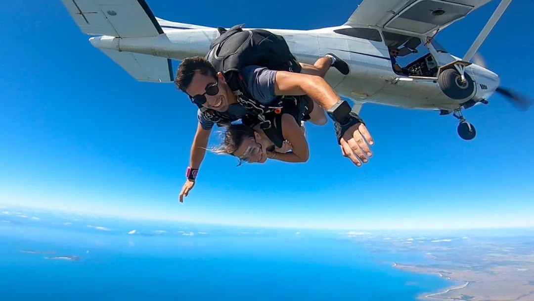 Tandem skydive over Airlie Beach with ocean view and beach landing.