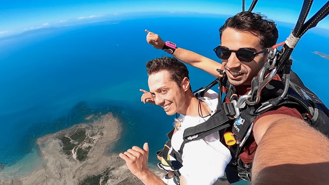 Tandem skydive over Airlie Beach with ocean view and beach landing.