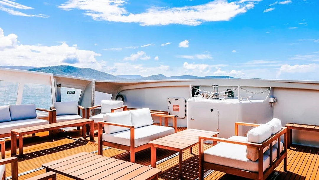 Outdoor seating area on a boat deck during ZigZag Whitsundays Day Tour.
