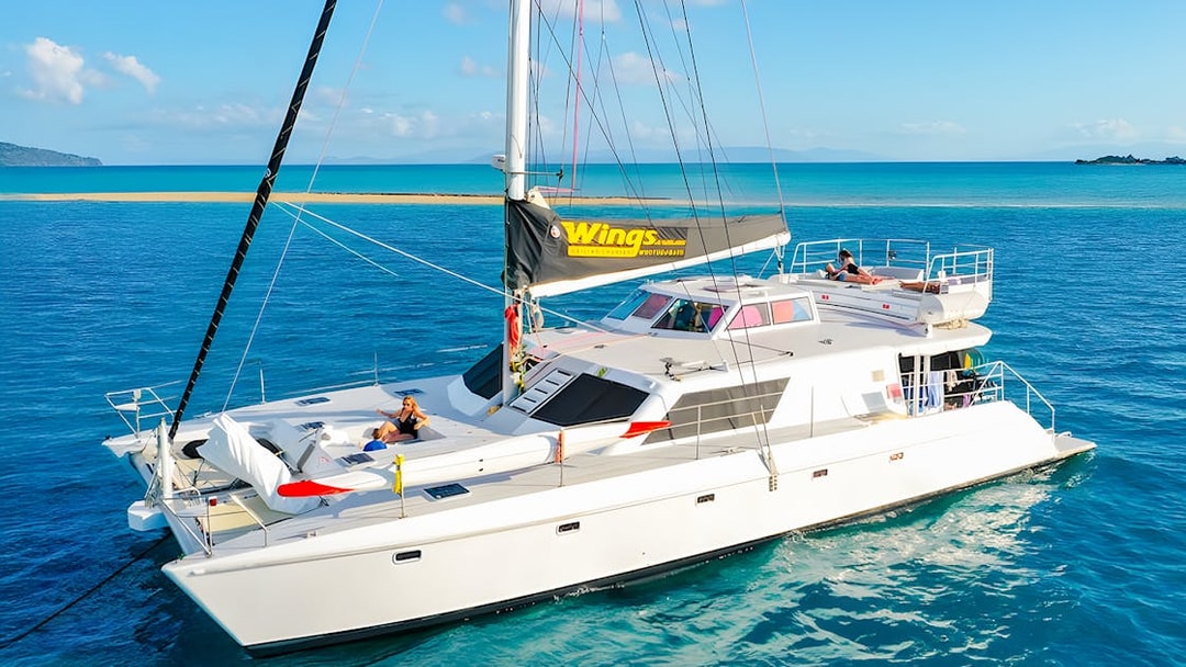 Tourists relaxing on a chartered catamaran in the Whitsundays.