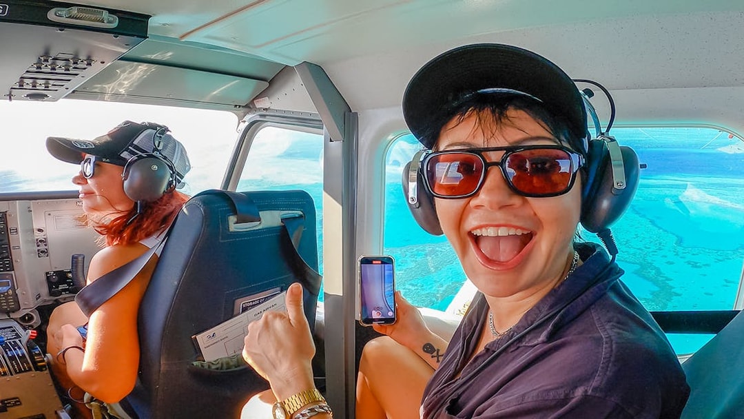 Scenic flight over Whitsundays with passengers enjoying aerial views of turquoise waters.