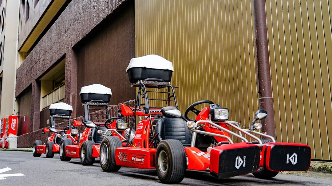 Red go-karts lined up on a street in Akihabara, Tokyo, ready for a driving experience.