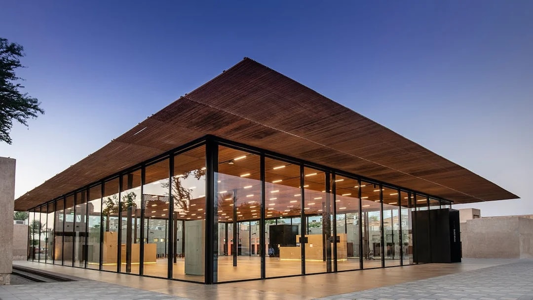 Modern glass building of Al Shindagha Museum in Dubai at dusk.