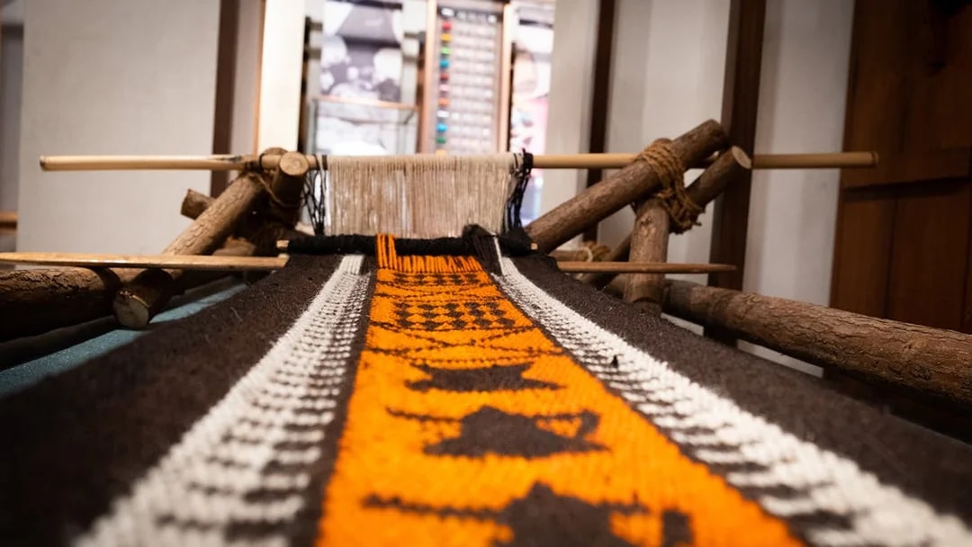 Traditional loom with colorful woven fabric at Al Shindagha Museum, Dubai.