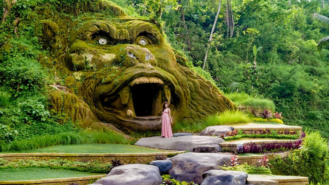 Lady standing near gorilla cave entrance at Alas Harum, Bali.