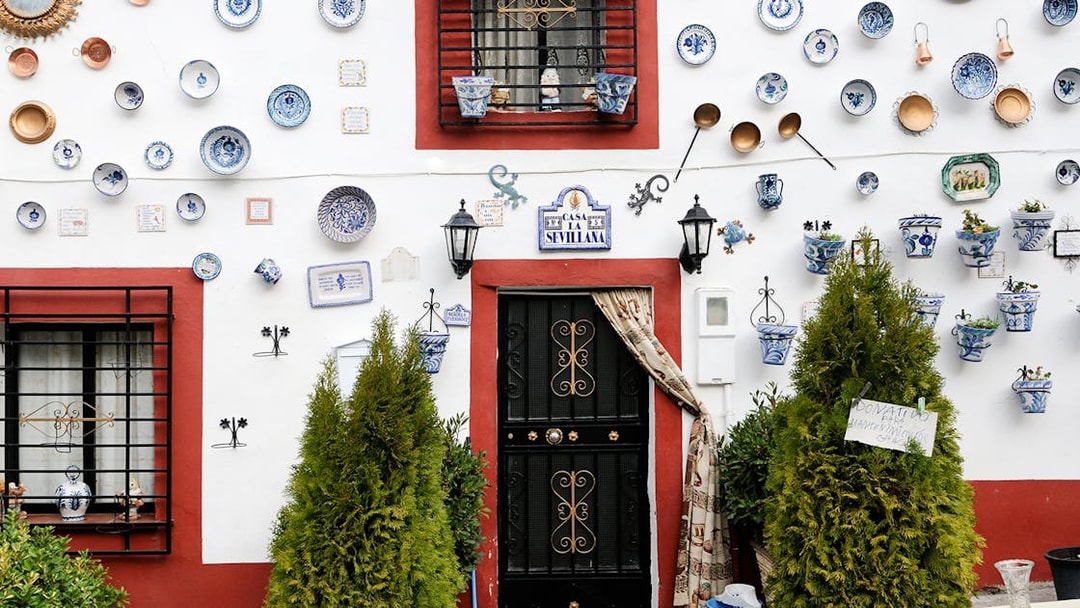 Colorful ceramic plates and pots on a white wall in Albaicin, Granada.