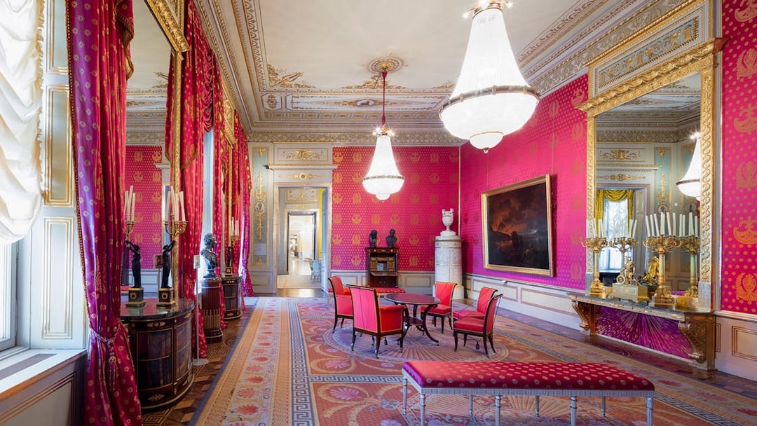 Habsburg State Rooms with ornate chandeliers, red drapes, and elegant furnishings.