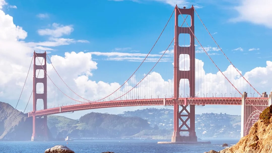 Golden Gate Bridge spanning San Francisco Bay under a clear sky.
