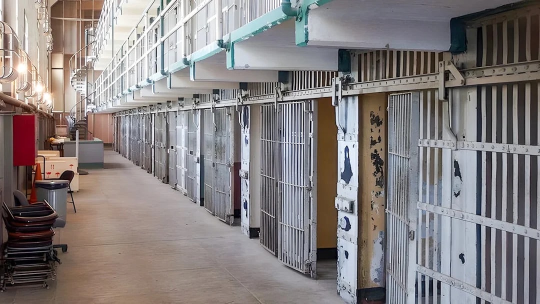 Prison cells on Alcatraz Island, San Francisco, with open barred doors and a walkway.
