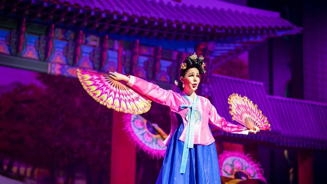 Performer in traditional costume with fans at Alcazar Cabaret Show.
