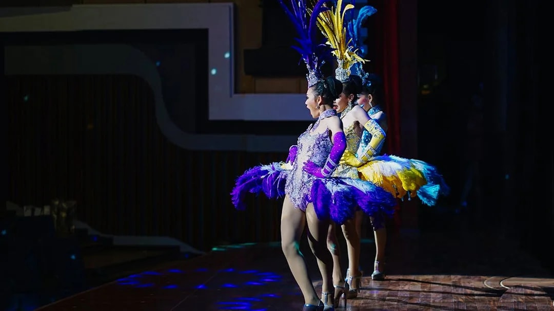 Performers in colorful costumes on stage at Alcazar Cabaret Show, Pattaya.