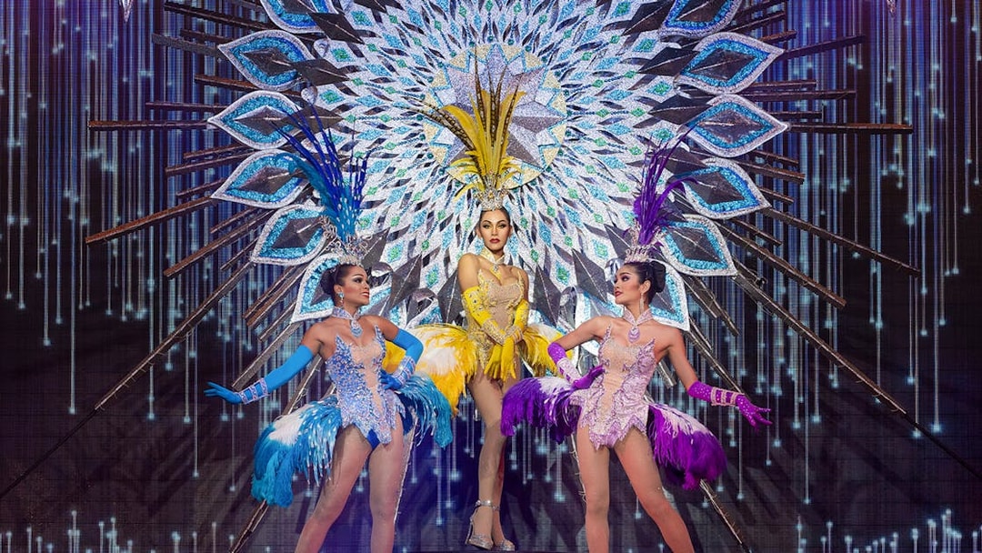 Performers in vibrant costumes on stage at Alcazar Cabaret, Pattaya, Thailand.