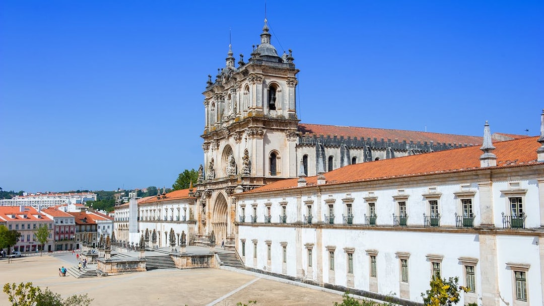 Alcobaça Monastery exterior with ornate facade and surrounding courtyard in Portugal.