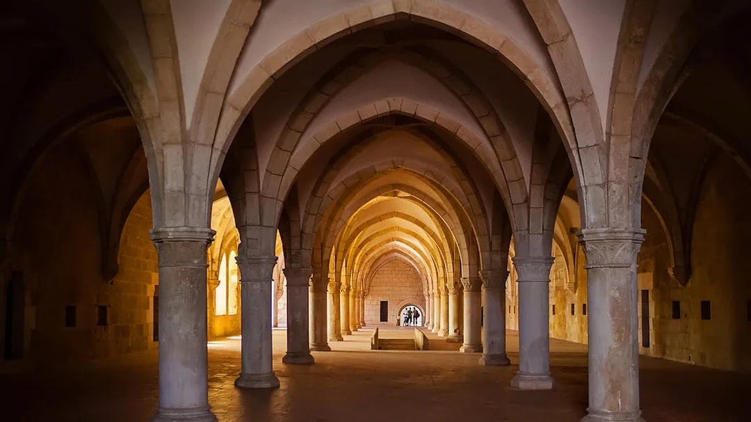 Alcobaça Monastery interior with vaulted arches and stone columns.
