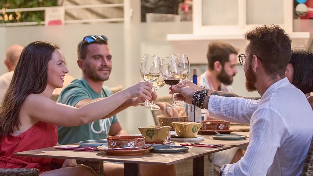 Group toasting with wine at Alegría Flamenco & Gastronomia dining experience.