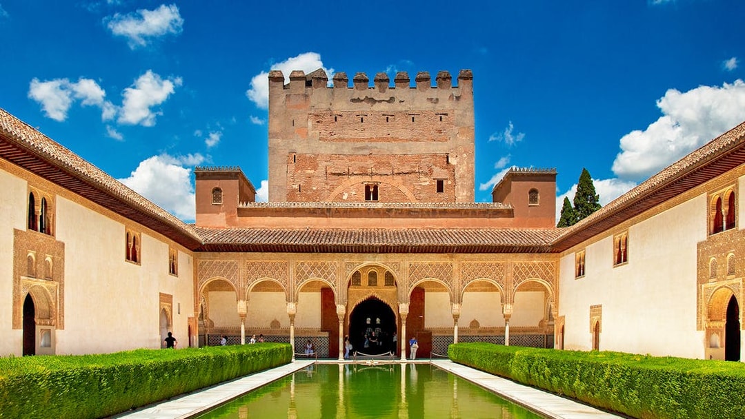 Alhambra's courtyard with reflecting pool and Moorish architecture, Granada, Spain.
